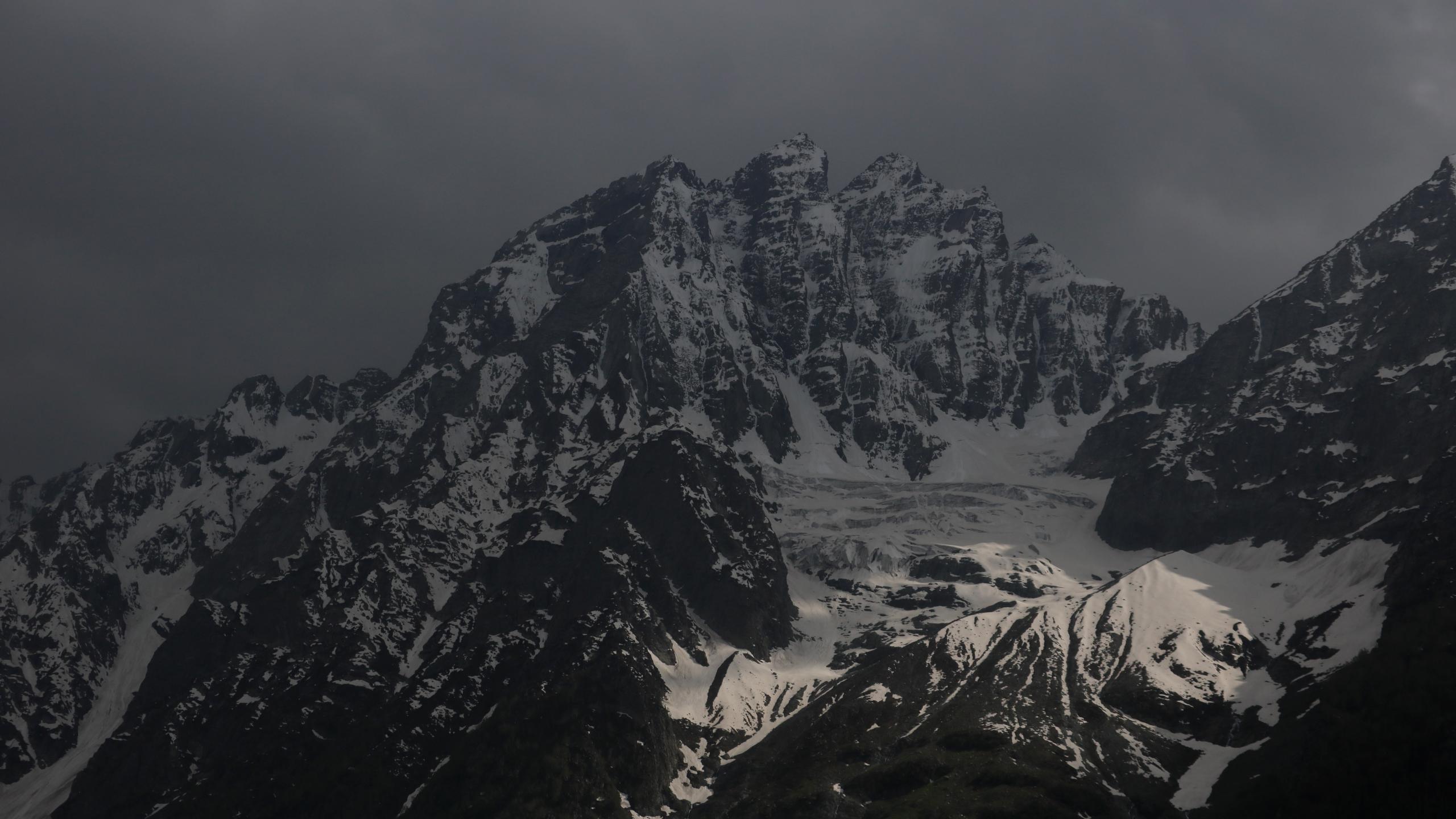 a_snowy_mountain_with_dark_clouds.jpg