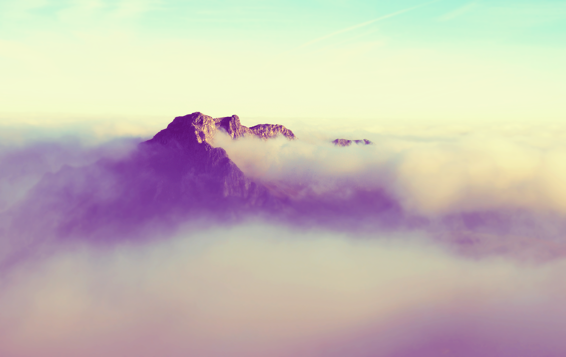 a_mountain_with_clouds_above_it.png